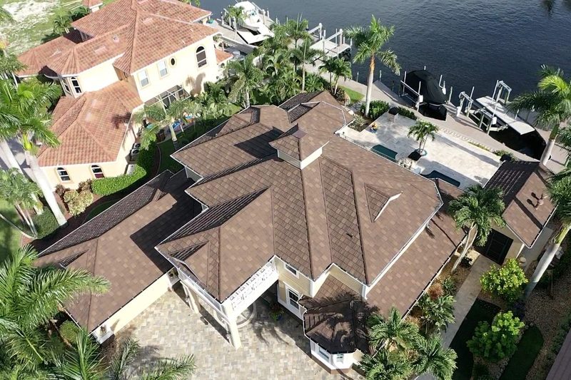 Aerial view of a waterfront home with a new brown DECRA stone-coated steel roof